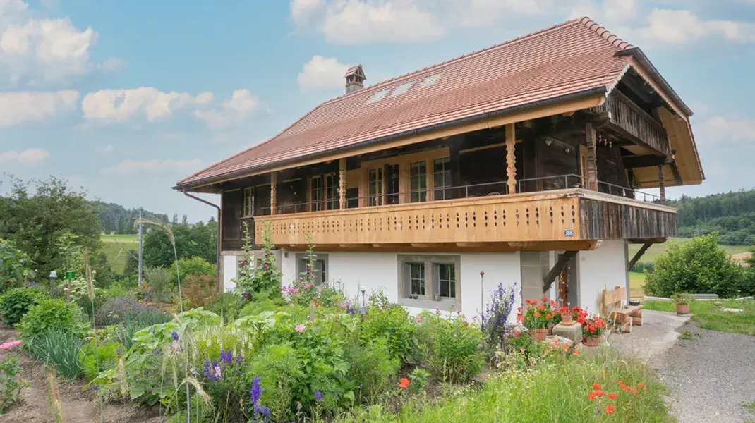 Blühender Garten mit viel Ertrag, Stöckli im Hintergrund mit blauem Himmel